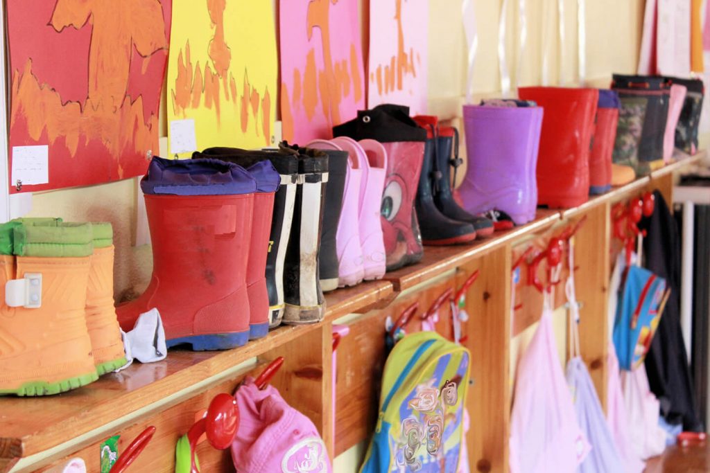 Childrens gum boots stacked on shelf at childcare center in the New England area near Coffs Harbour